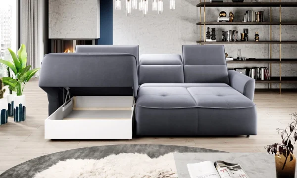 Canapé d'angle moderne gris clair avec rangement intégré ouvert, dans un salon élégant avec une cheminée, étagères et plantes en arrière-plan.