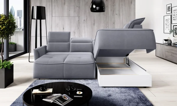 Canapé d'angle gris moderne avec coffre de rangement ouvert, appuie-têtes ajustables, dans un salon épuré avec un tapis bleu et des éléments de décoration minimalistes.