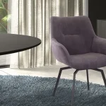 Chaise Teddy en tissu violet avec pieds en métal noir, mise en scène dans un intérieur contemporain avec tapis moelleux et grande luminosité naturelle.